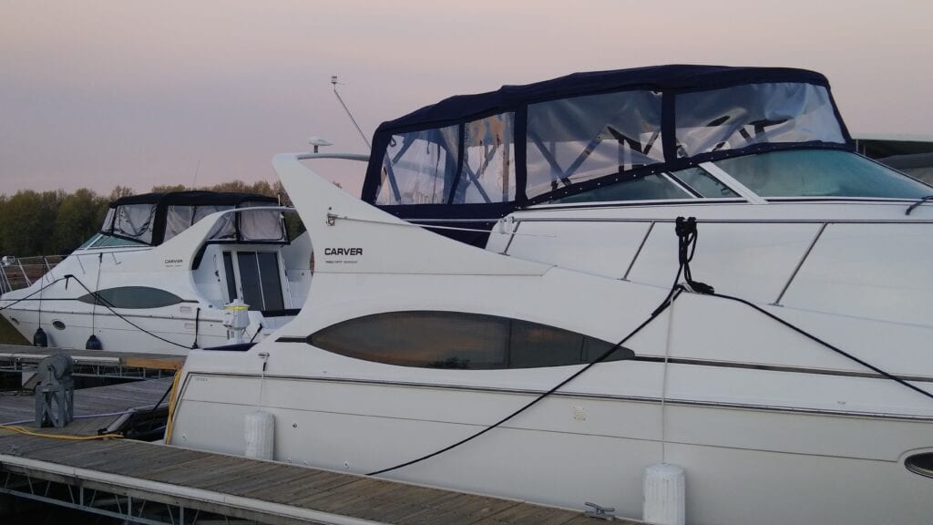 A boat parked at the dock with its doors open.