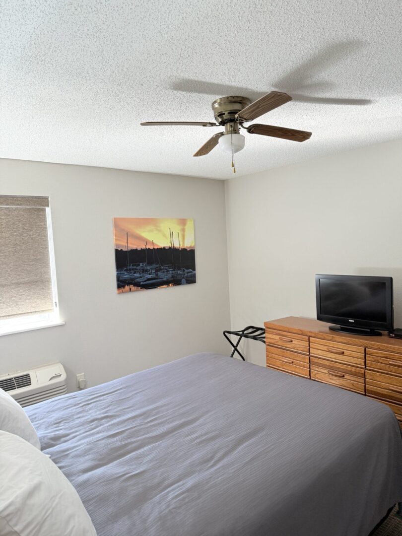 Hotel room with king bed and sunset art.